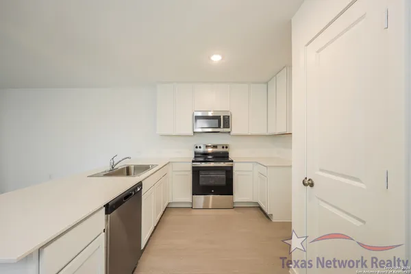 a kitchen with stainless steel appliances granite countertop a sink and a stove