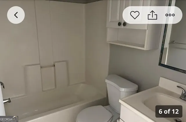 a white toilet sitting next to a bath tub