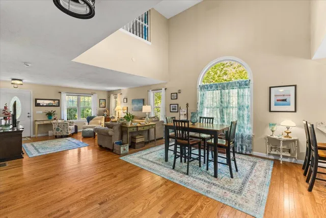 a living room with furniture a dining table and a large window
