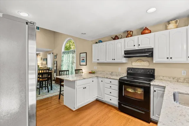 a kitchen with granite countertop a stove a sink and a refrigerator