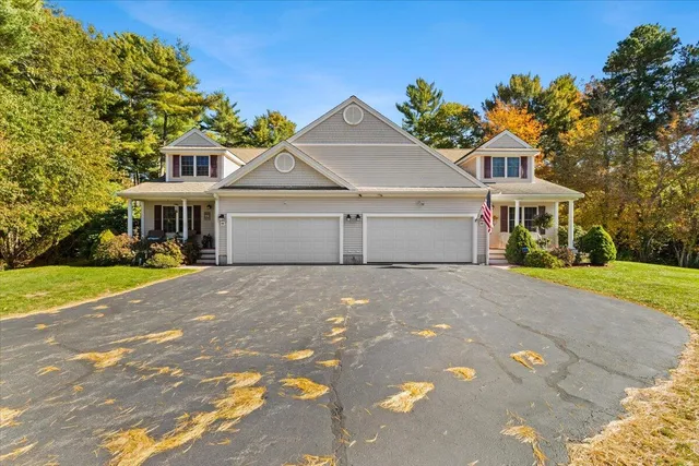 a view of a white house with a big yard and large trees