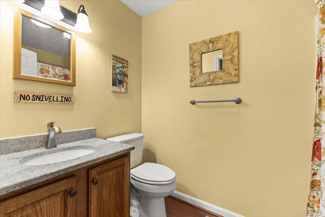 a bathroom with a granite countertop toilet sink and mirror