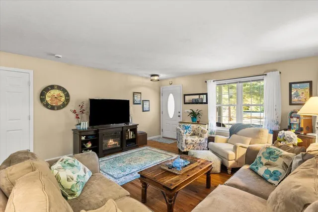 a living room with furniture a flat screen tv and a large window