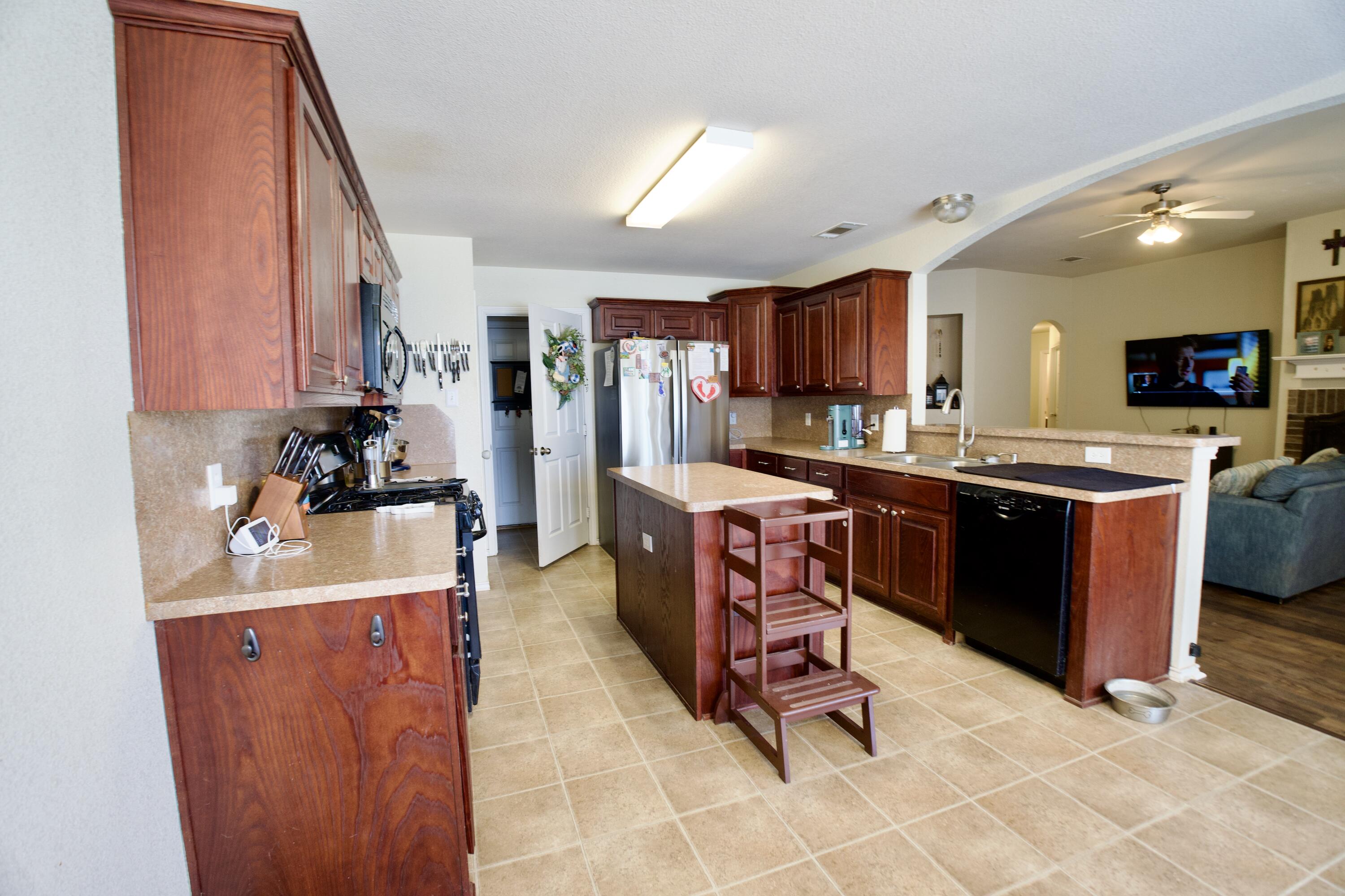 8811 16th Street Lubbock, TX 79416 - Photo 12 of 17 a kitchen with stainless steel appliances a sink a stove a refrigerator cabinets and a dining table