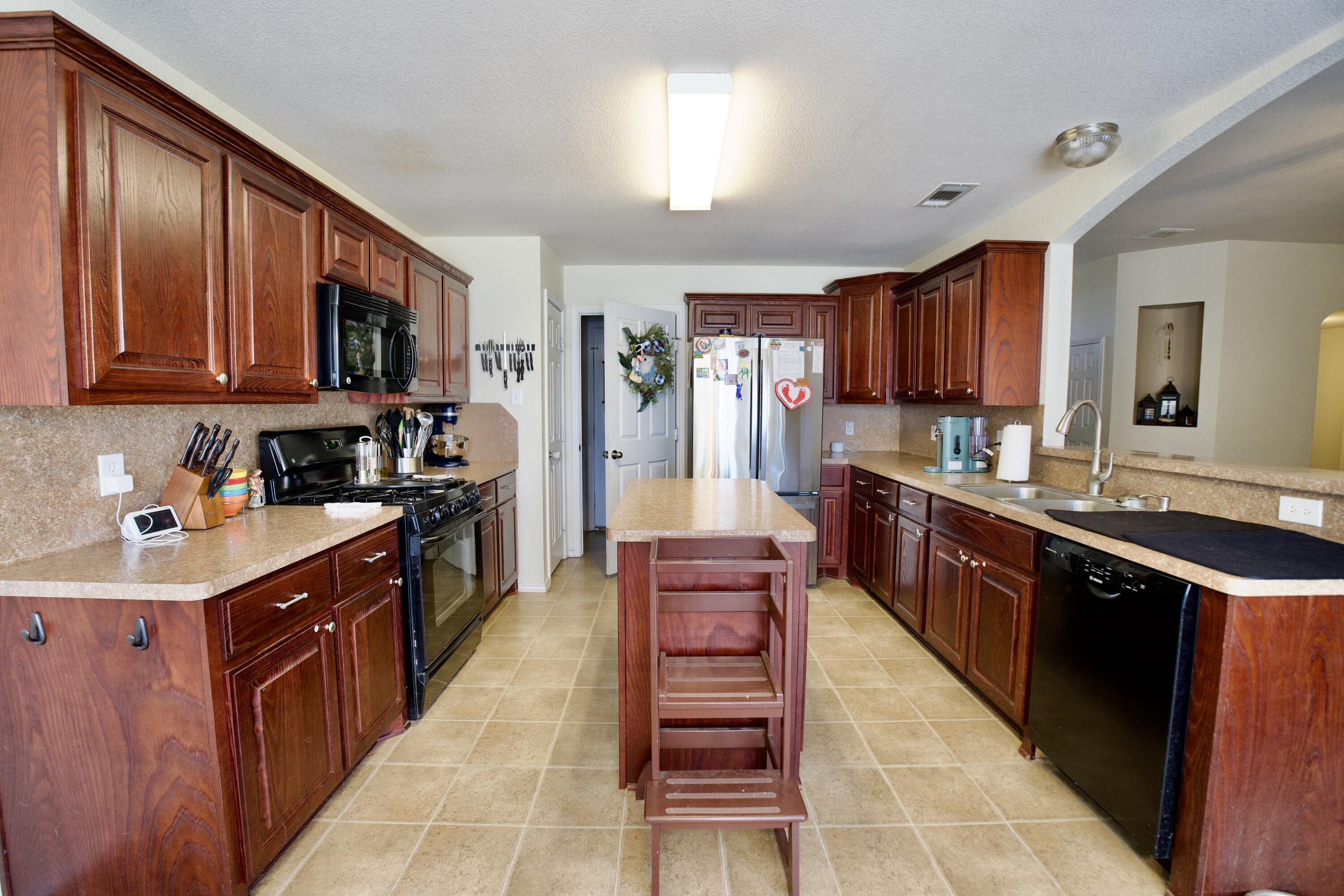 8811 16th Street Lubbock, TX 79416 - Photo 13 of 17 a open kitchen with stainless steel appliances granite countertop a stove top oven a sink dishwasher and cabinets with wooden floor