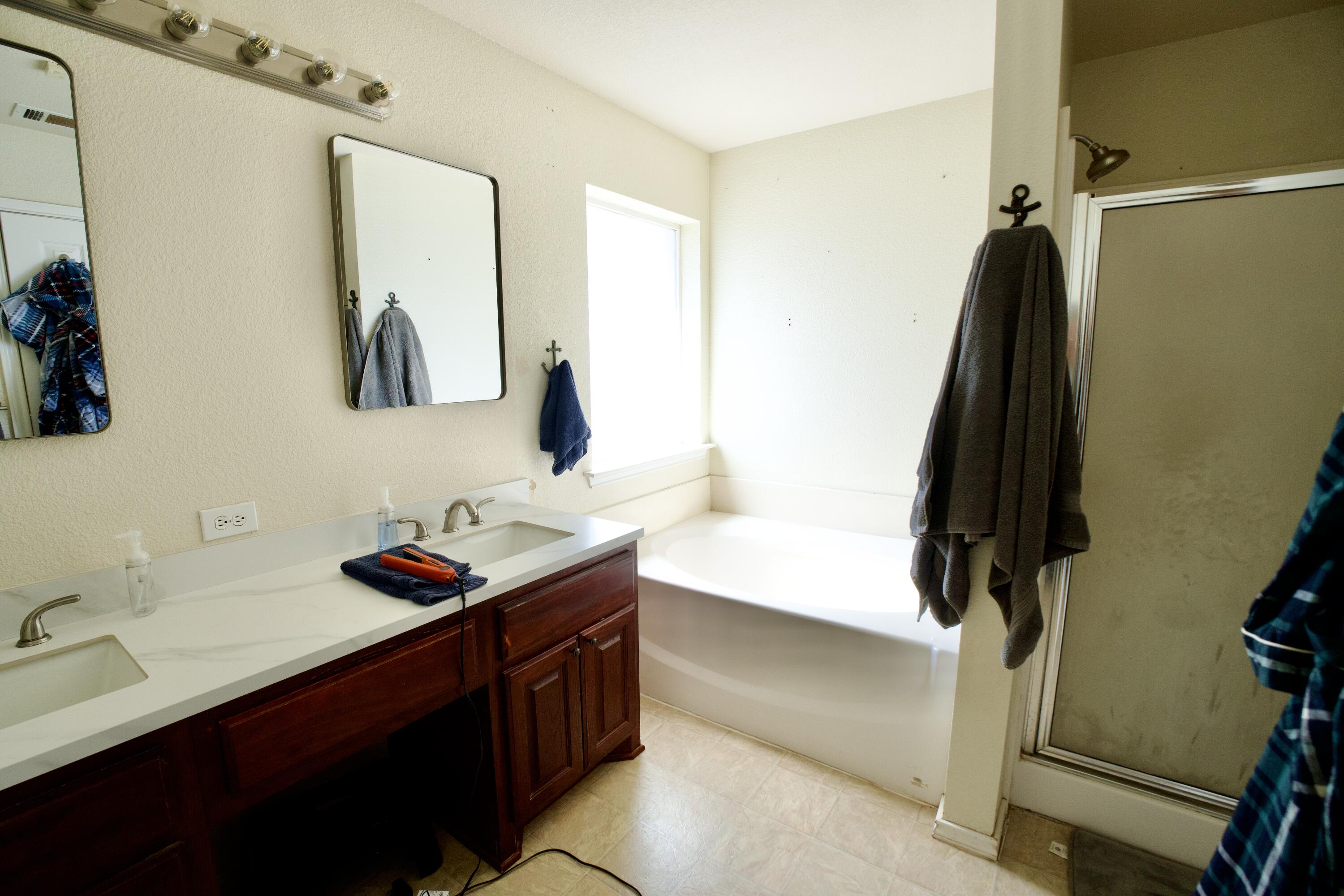8811 16th Street Lubbock, TX 79416 - Photo 9 of 17 a bathroom with a sink vanity tub and a mirror