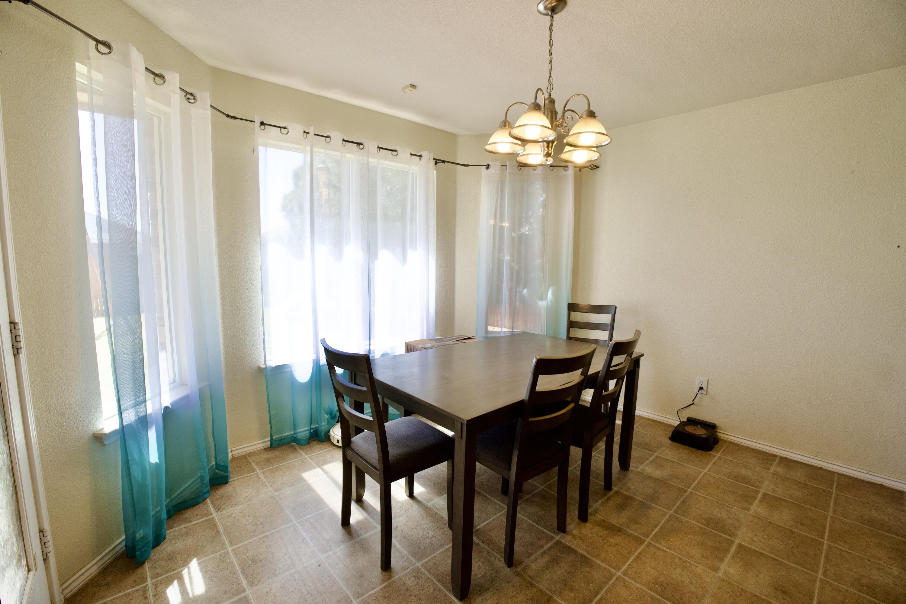8811 16th Street Lubbock, TX 79416 - Photo 10 of 17 a view of a dining room with furniture and chandelier