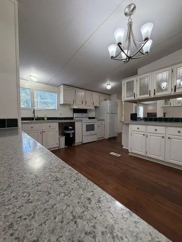 a large kitchen with granite countertop a large counter top stainless steel appliances and cabinets