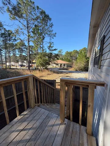 a view of a balcony with wooden floor and fence