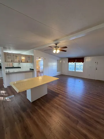 a living room with kitchen island granite countertop wooden floor and a fireplace