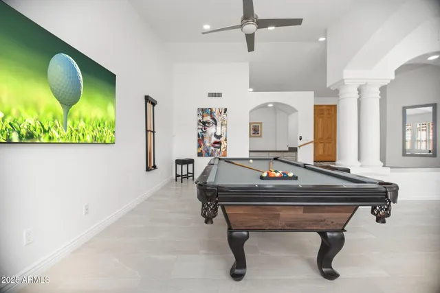 a room with pool table and windows