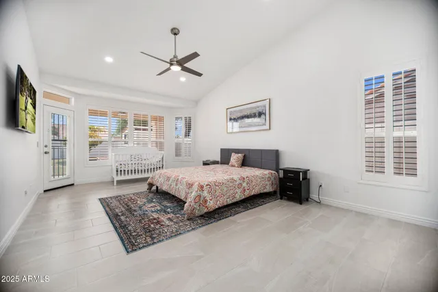 a bedroom with a large bed a flat screen tv and couches