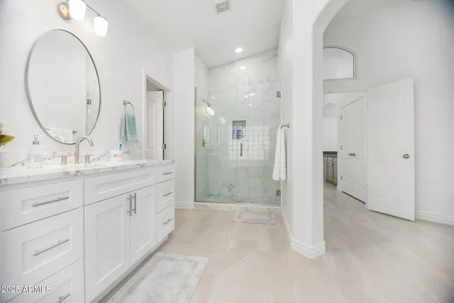 a bathroom with a double vanity sink mirror and shower