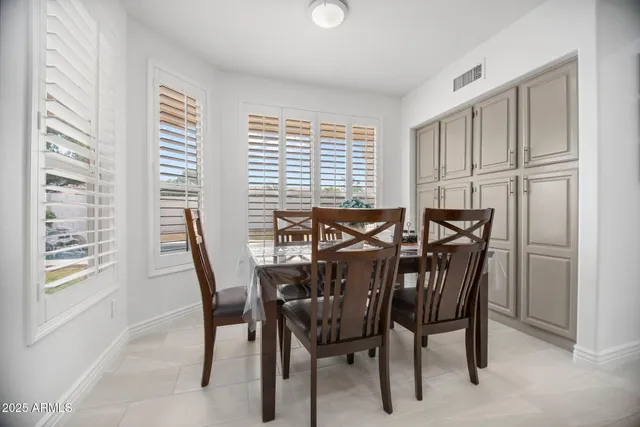 a dining room with furniture and large windows