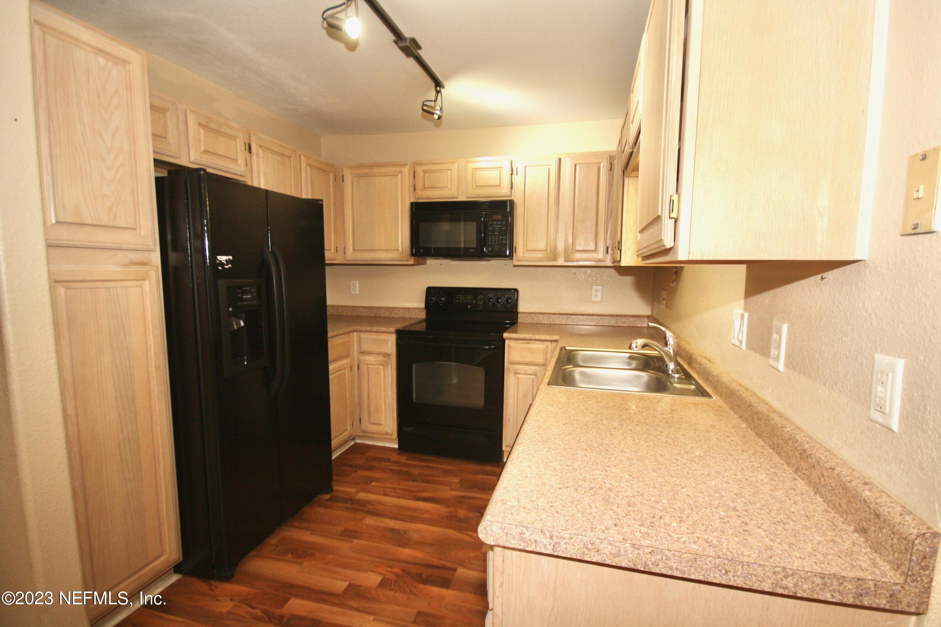 10150 Belle Rive Boulevard, Unit 2303 Jacksonville, FL 32256 - Photo 17 of 28 a kitchen with granite countertop a refrigerator a stove top oven and a sink