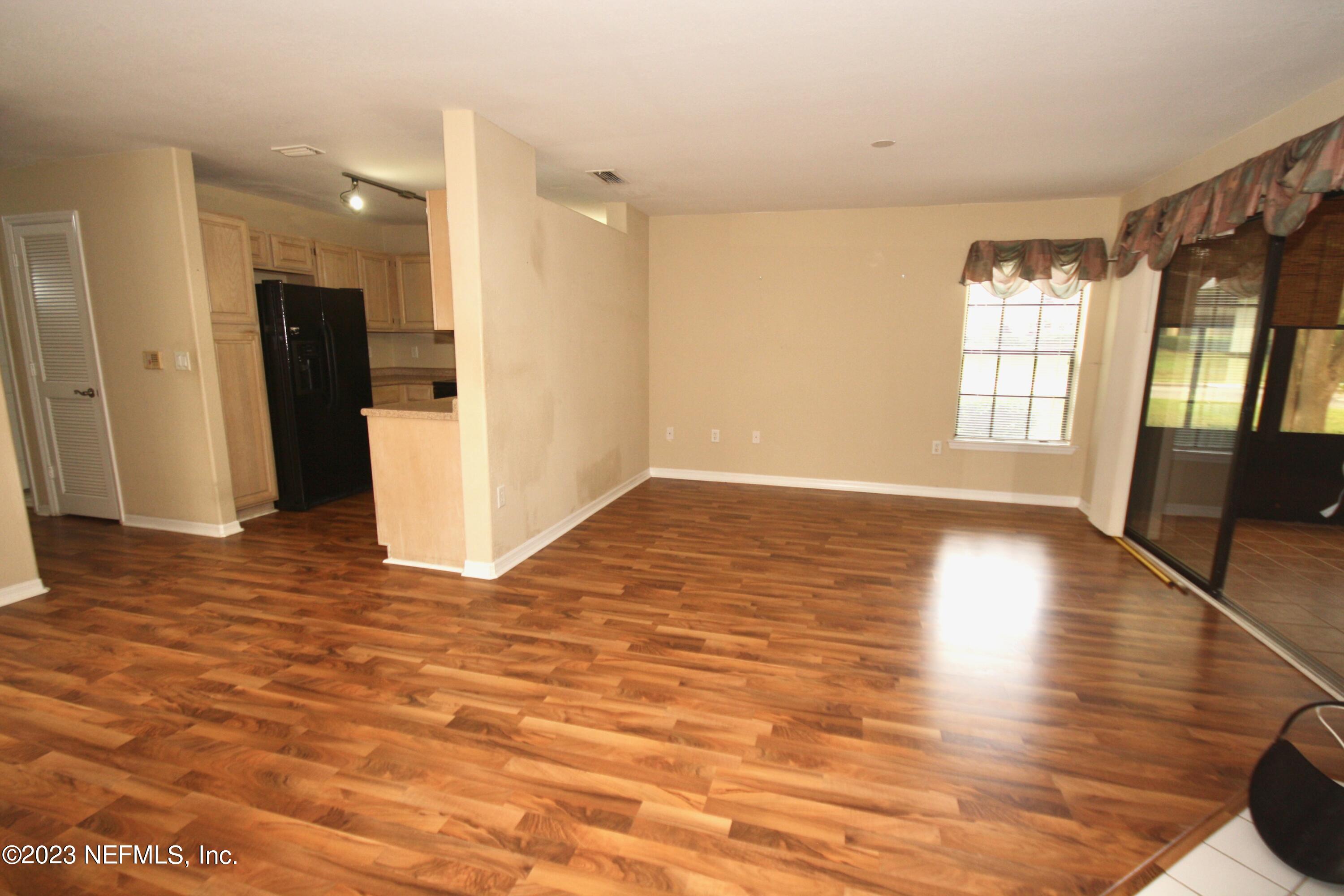 10150 Belle Rive Boulevard, Unit 2303 Jacksonville, FL 32256 - Photo 4 of 28 a view of an empty room with window and wooden floor