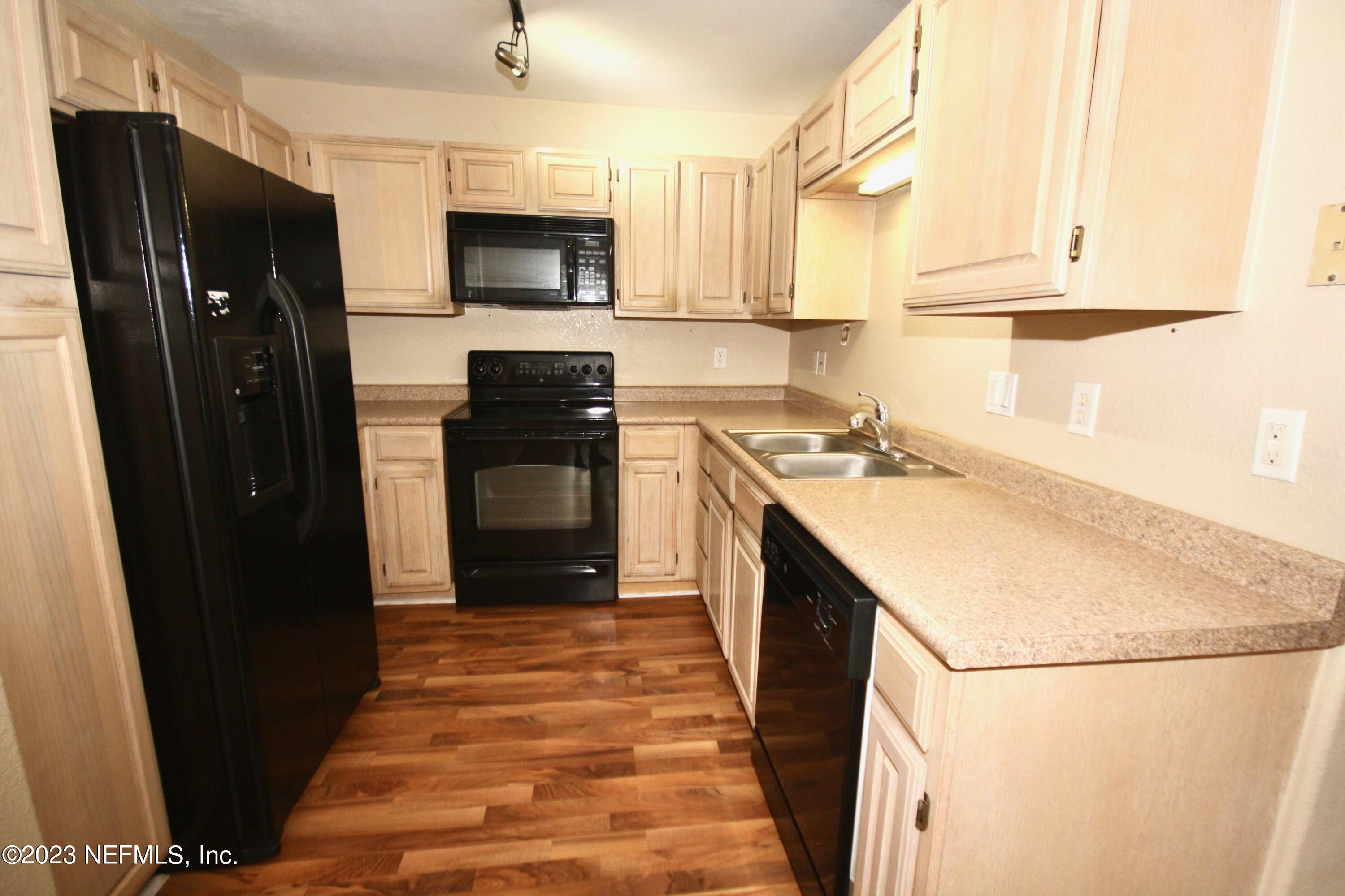 10150 Belle Rive Boulevard, Unit 2303 Jacksonville, FL 32256 - Photo 6 of 28 a kitchen with a sink a refrigerator and a stove