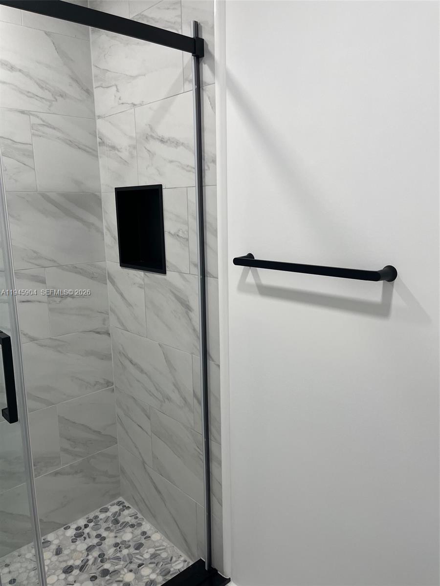1045 Southwest 122nd Court Miami, FL 33184 - Photo 14 of 44 a bathroom with a shower and a tiled wall