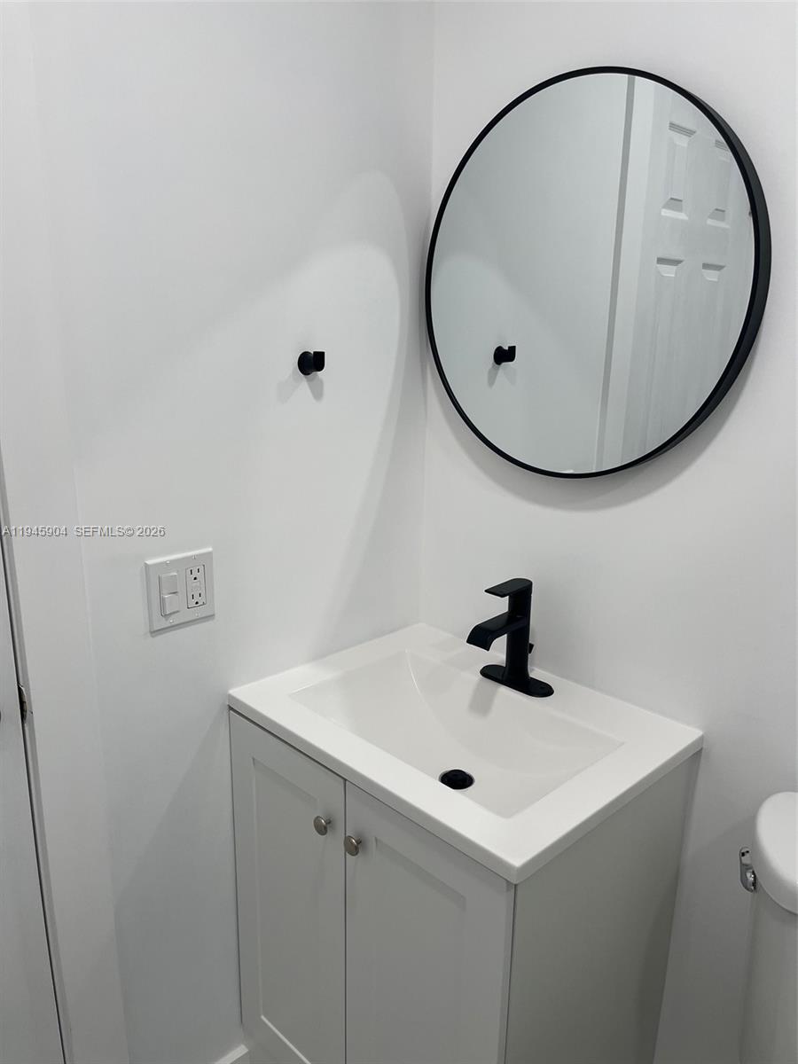 1045 Southwest 122nd Court Miami, FL 33184 - Photo 15 of 44 a bathroom with a sink a mirror and vanity