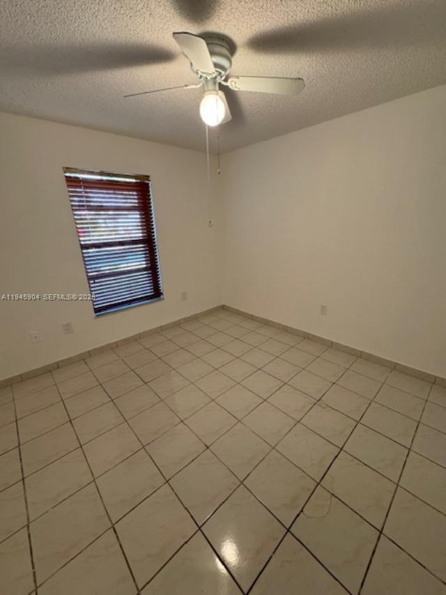 1045 Southwest 122nd Court Miami, FL 33184 - Photo 18 of 44 an empty room with windows and ceiling fan