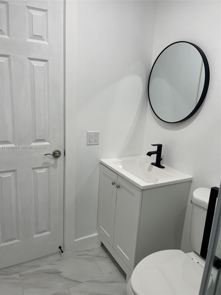 1045 Southwest 122nd Court Miami, FL 33184 - Photo 28 of 44 a bathroom with a sink mirror and toilet