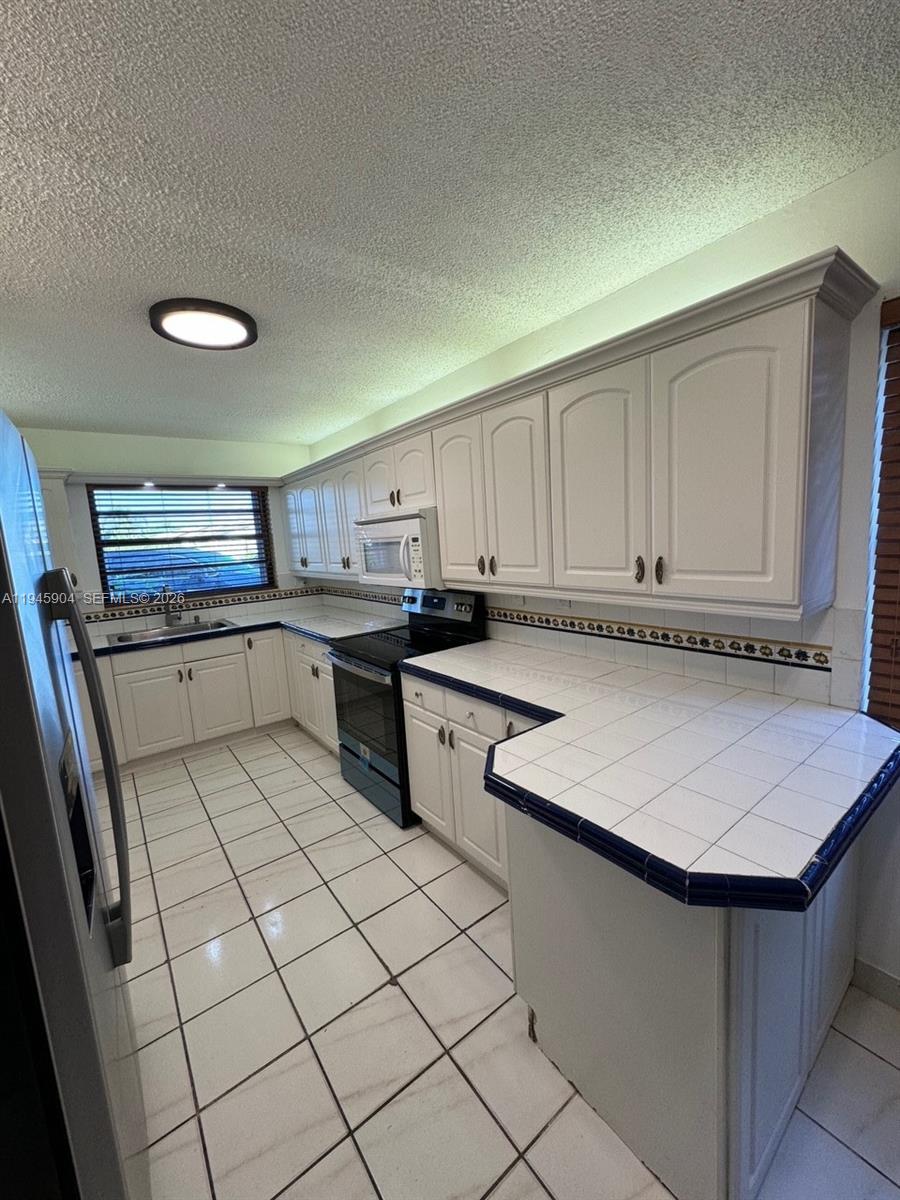 1045 Southwest 122nd Court Miami, FL 33184 - Photo 6 of 44 a kitchen with stainless steel appliances granite countertop a sink stove and refrigerator