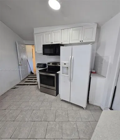 a kitchen with stainless steel appliances a refrigerator a stove a microwave and cabinets