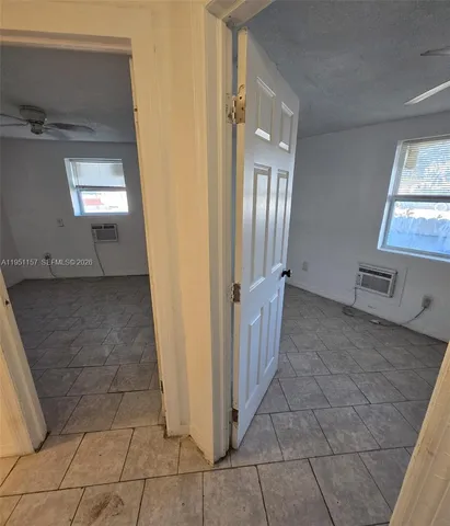 a view of a hallway with wooden floor and a living room