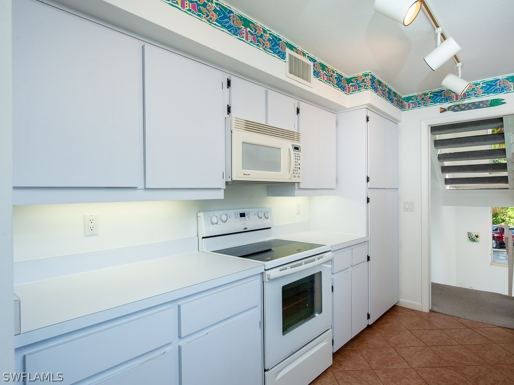 965 Beach Road Sanibel, FL 33957 - Photo 15 of 34 a view of a kitchen with cabinets appliances and a wooden floor