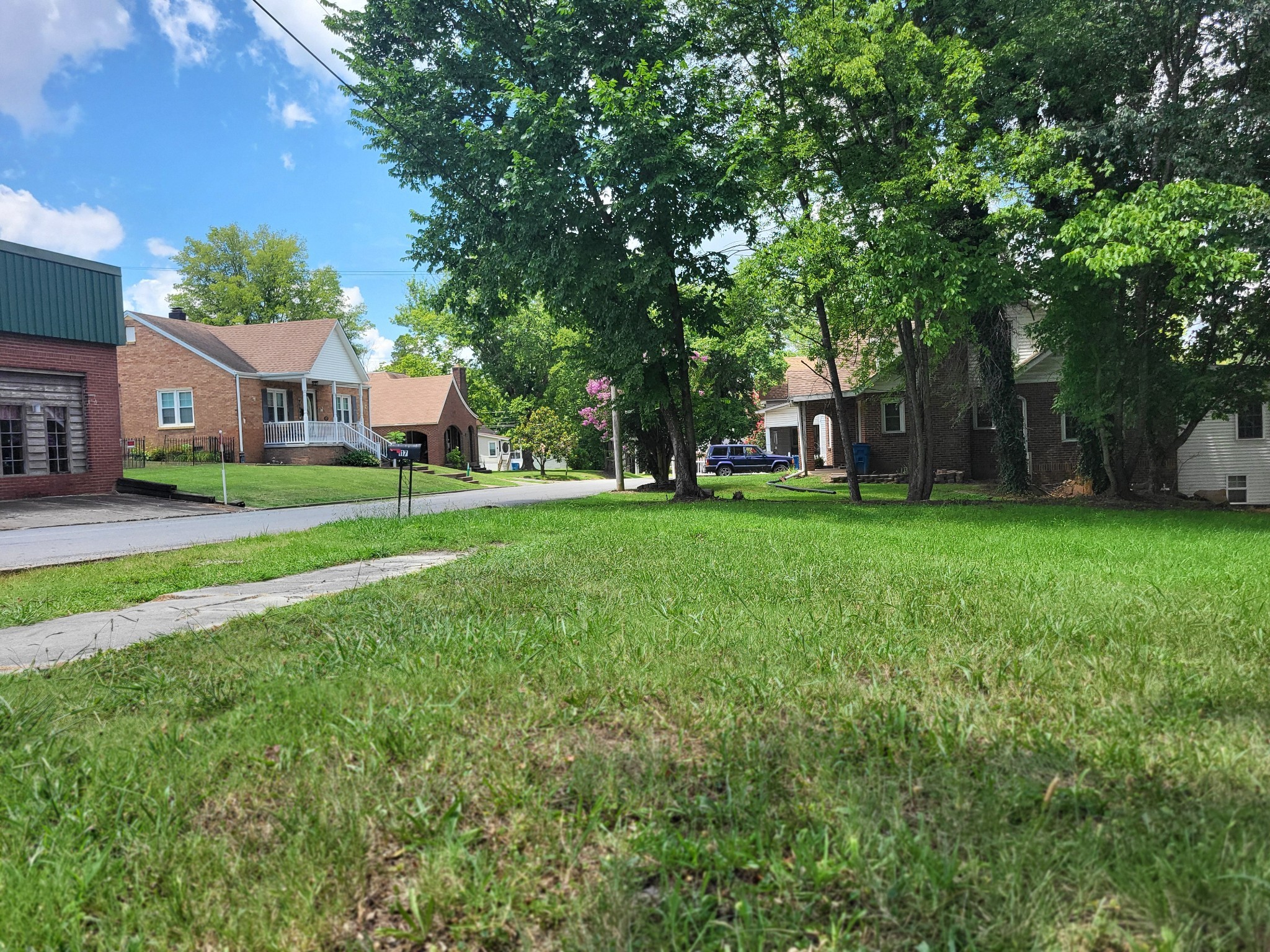 a view of a house with a big yard and large trees