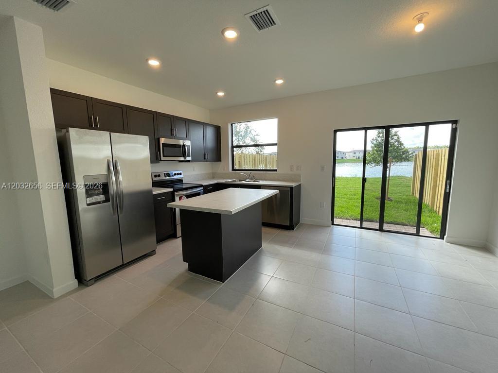 10144 Southwest 228th Terrace Miami, FL 33190 - Photo 7 of 23 a kitchen with stainless steel appliances granite countertop a refrigerator a sink a stove with cabinets