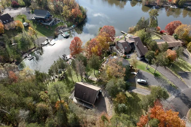 a aerial view of a house with a yard and lake view