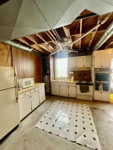 a kitchen with stainless steel appliances kitchen island granite countertop a sink and cabinets