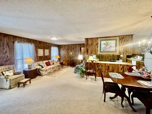 a living room with furniture kitchen view and a table