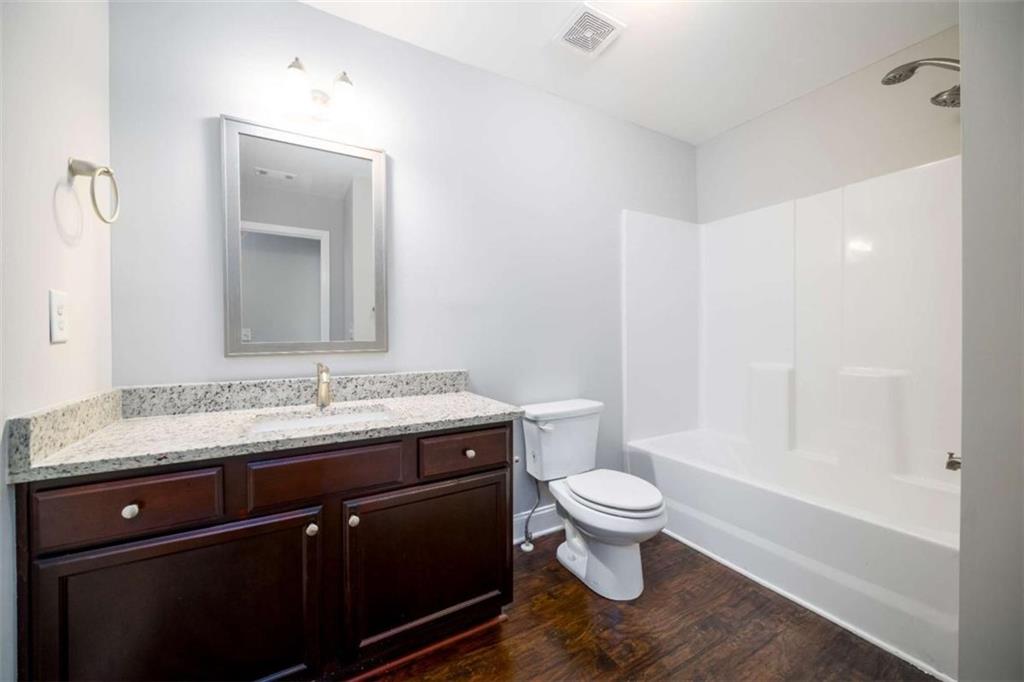 68 Crescent Commons Drive Dallas, GA 30157 - Photo 20 of 26 a bathroom with a granite countertop toilet a sink and a mirror