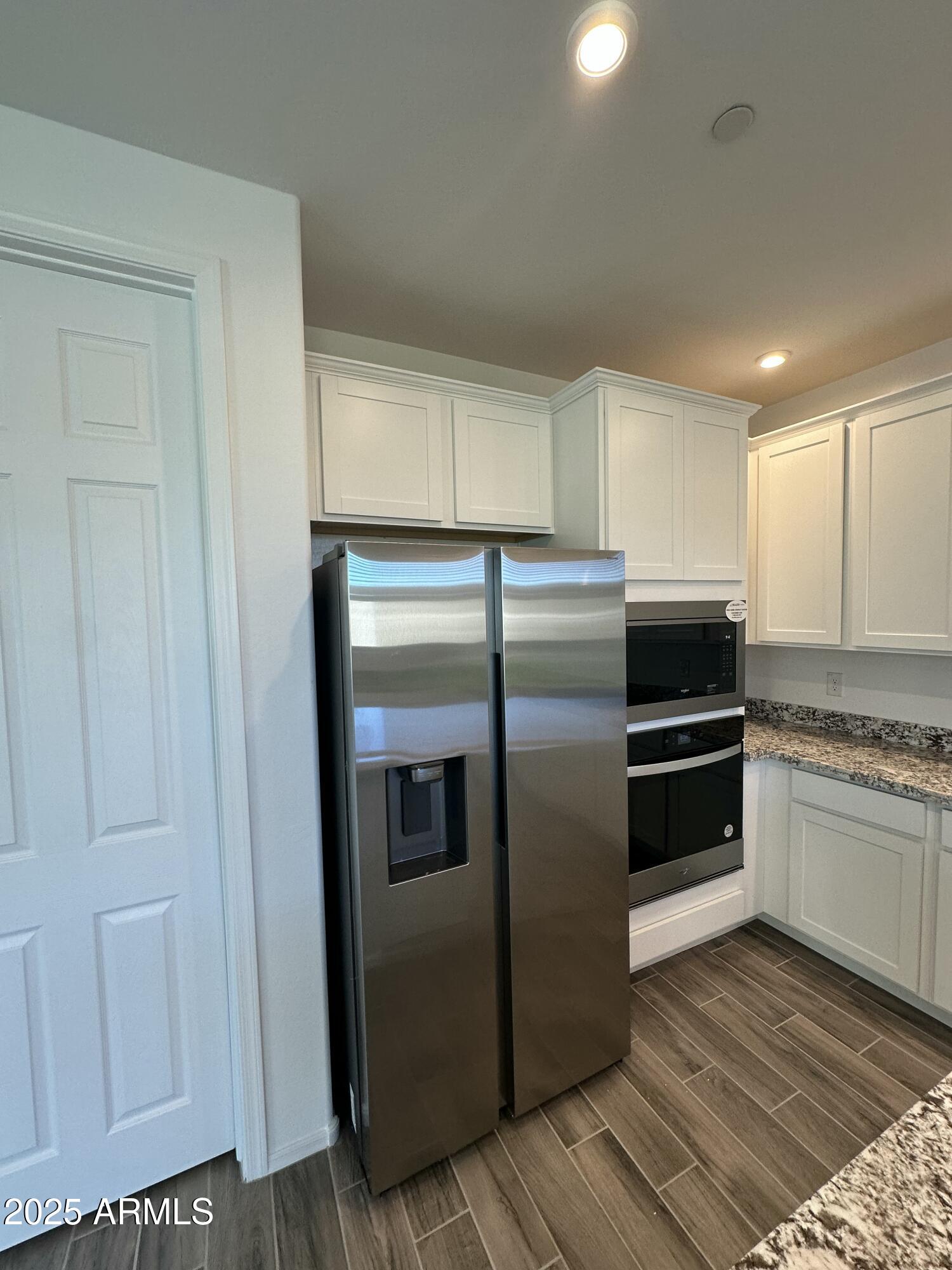 13330 West Eagle Feather Road Peoria, AZ 85383 - Photo 6 of 34 a kitchen with granite countertop a refrigerator and a stove top oven