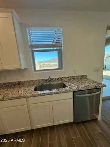 a kitchen with granite countertop a sink and a stove