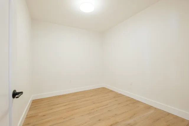 a view of a small space with wooden floor and a window