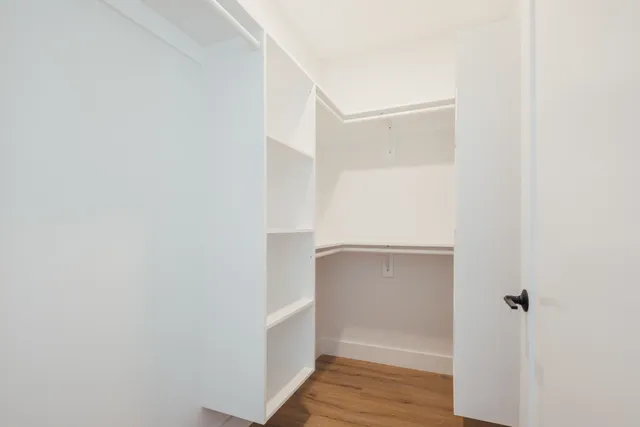 a view of walk in closet with empty racks