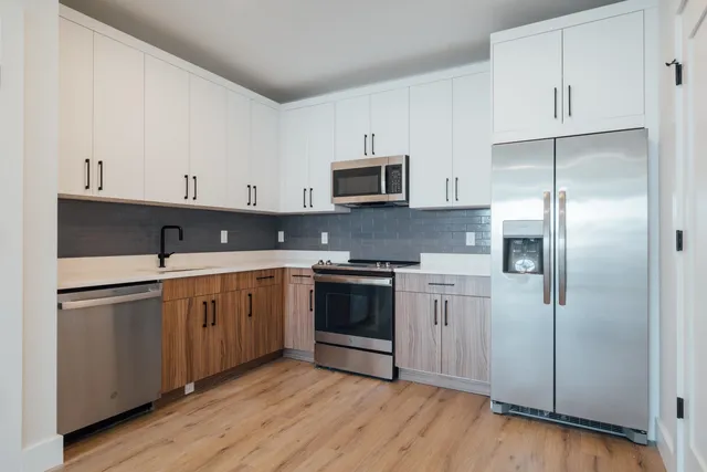 a kitchen with stainless steel appliances granite countertop a refrigerator and a stove top oven