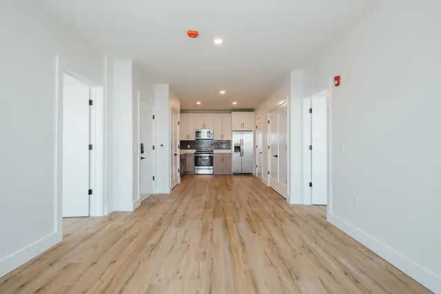 a view of a kitchen with wooden floor and a refrigerator
