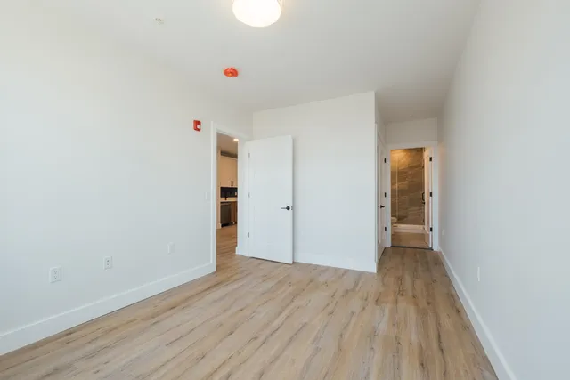 a view of an empty room with closet and a window