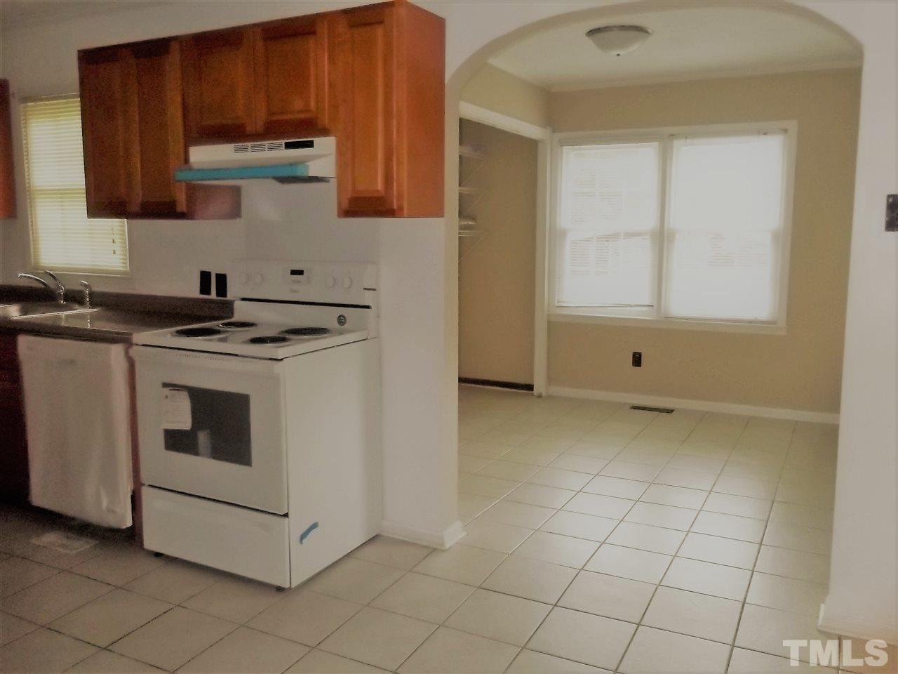 1298 Dick Holeman Road Timberlake, NC 27583 - Photo 3 of 17 a kitchen with granite countertop white cabinets and appliances