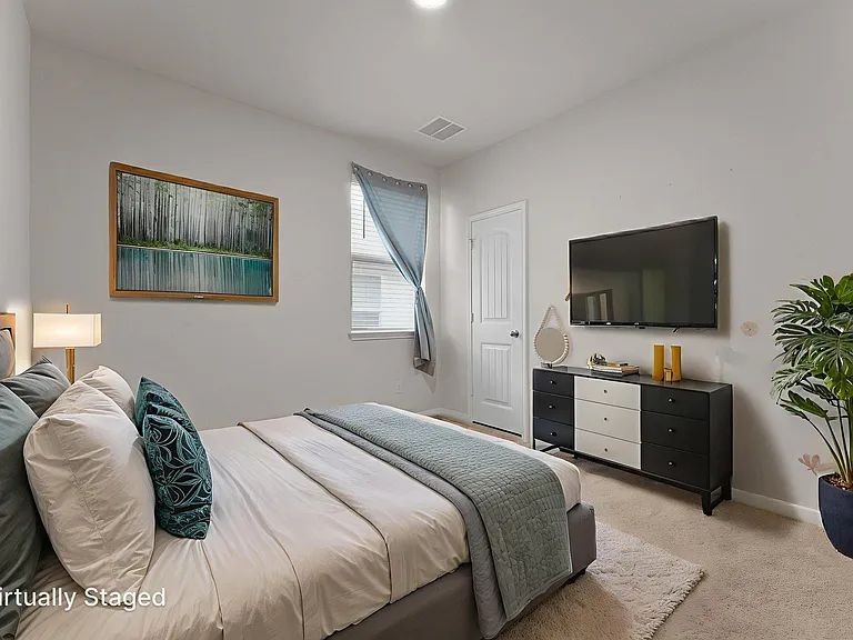 305 Evergreen Sumac Loop Kyle, TX 78640 - Photo 19 of 29 a bedroom with a bed and a flat screen tv