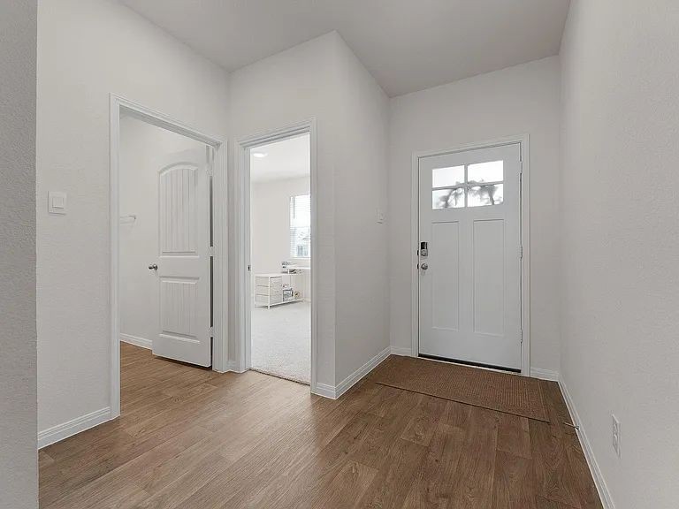 305 Evergreen Sumac Loop Kyle, TX 78640 - Photo 6 of 29 an empty room with wooden floor and windows