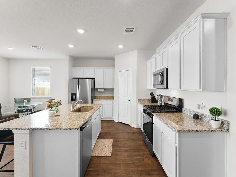 305 Evergreen Sumac Loop Kyle, TX 78640 - Photo 8 of 29 a kitchen with stainless steel appliances granite countertop a sink stove and refrigerator