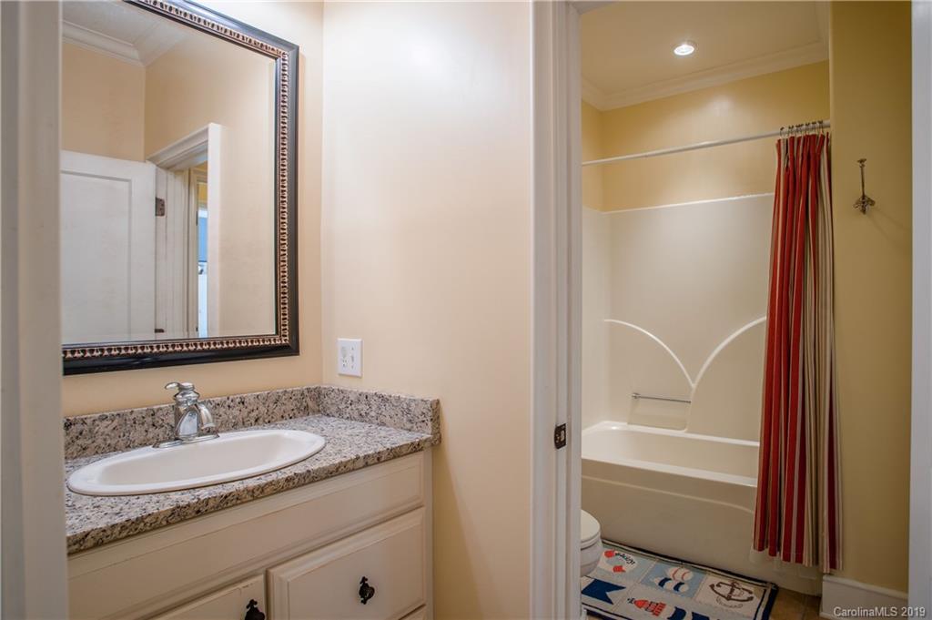 243 Trail Ridge Road Rutherfordton, NC 28139 - Photo 33 of 45 a bathroom with a granite countertop sink a mirror and a bathtub