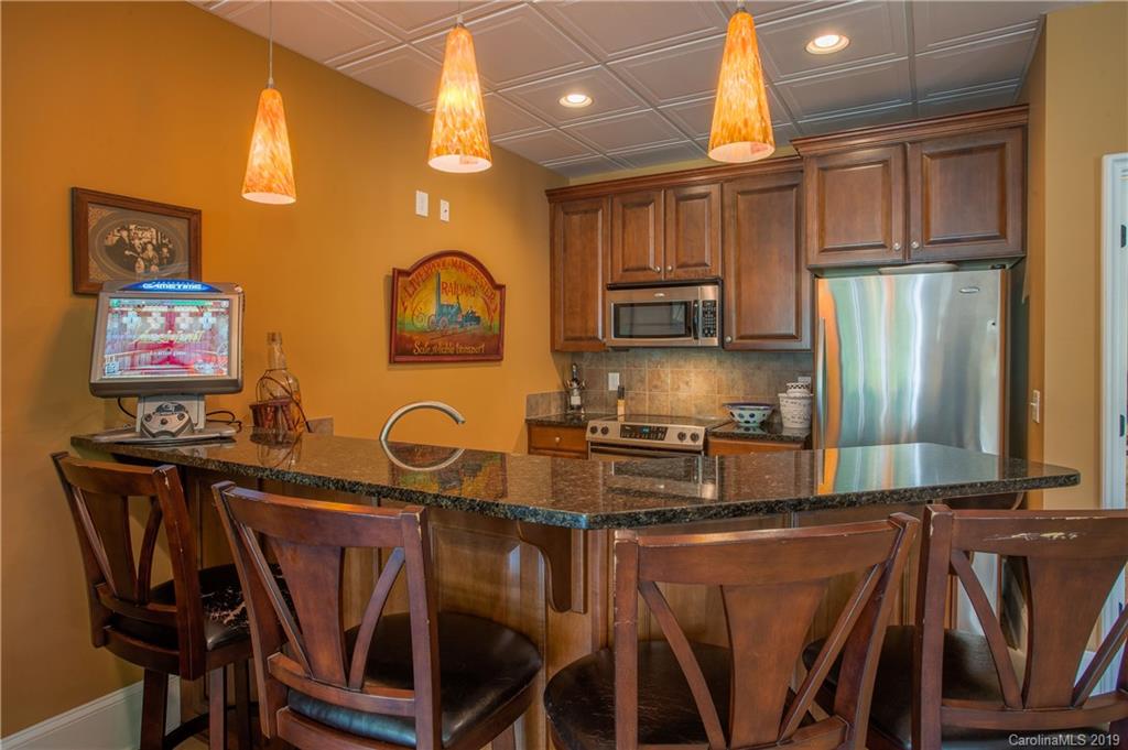 243 Trail Ridge Road Rutherfordton, NC 28139 - Photo 37 of 45 a kitchen with stainless steel appliances granite countertop a table chairs in it and wooden floors