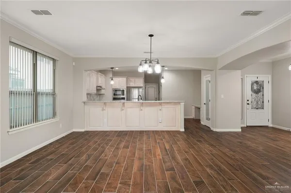 a view of a living room and kitchen with wooden floor