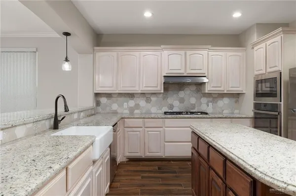 a kitchen with stainless steel appliances granite countertop a sink stove and cabinets